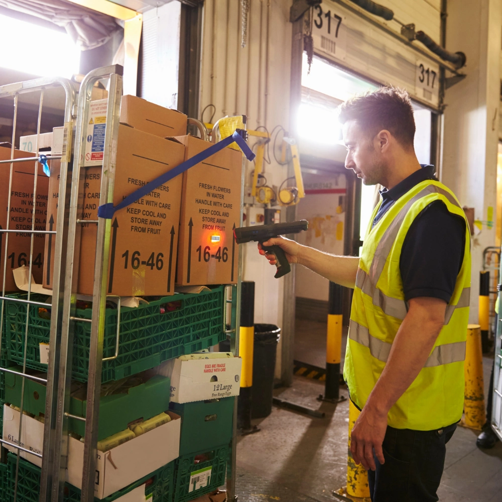 Worker scanning packages near warehouse dock doorsWorker scanning packages near warehouse dock doors.
